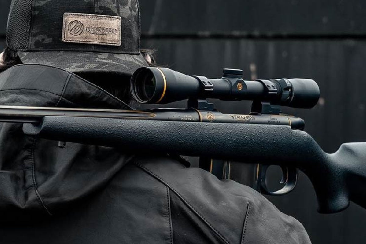 Man holding a 308 winchester rifle with a scope