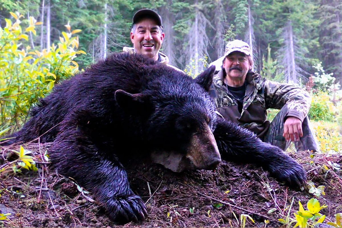 Two men with a downed bear