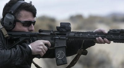 Man aiming an AR15 with a scope