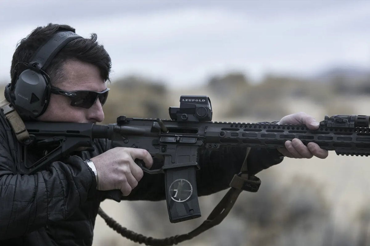 Man aiming AR15 rifle with scope