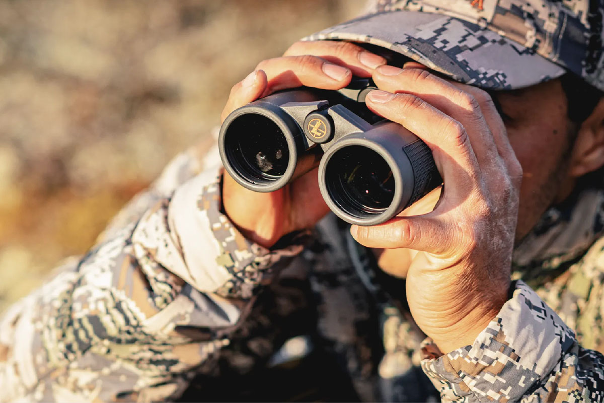 Man looking through binoculars while hunting