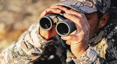Man using Leupold binoculars for hunting