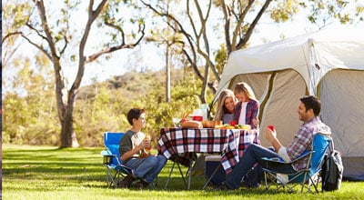 family outside in front of a large tent
