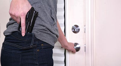 Man holding gun opening a door