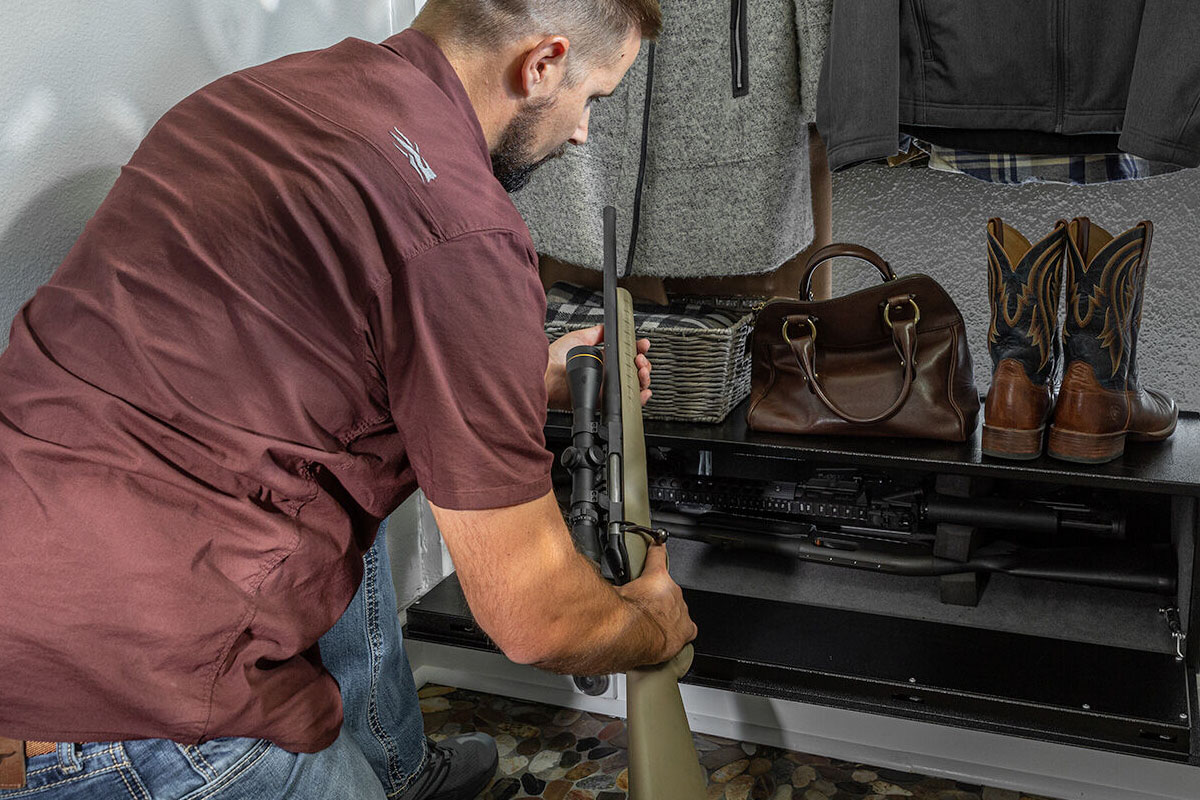 Man putting gun in gun safe