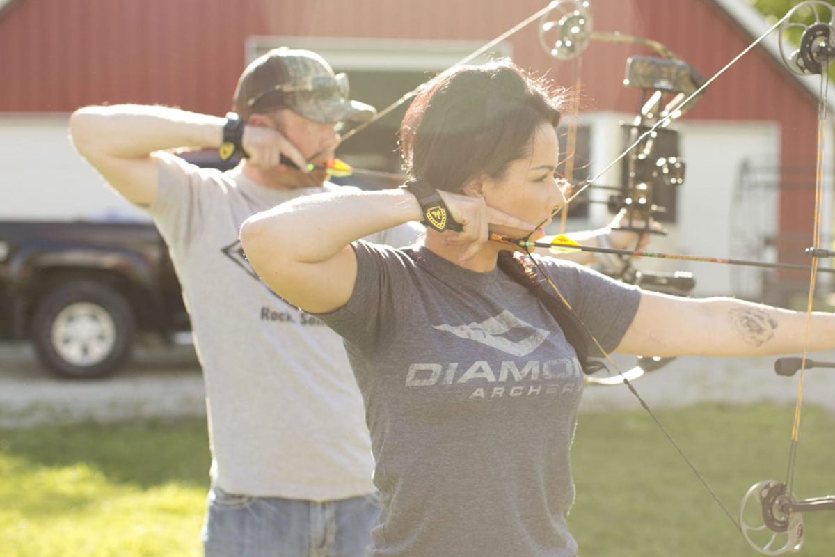 Couple shooting a bow and arrow