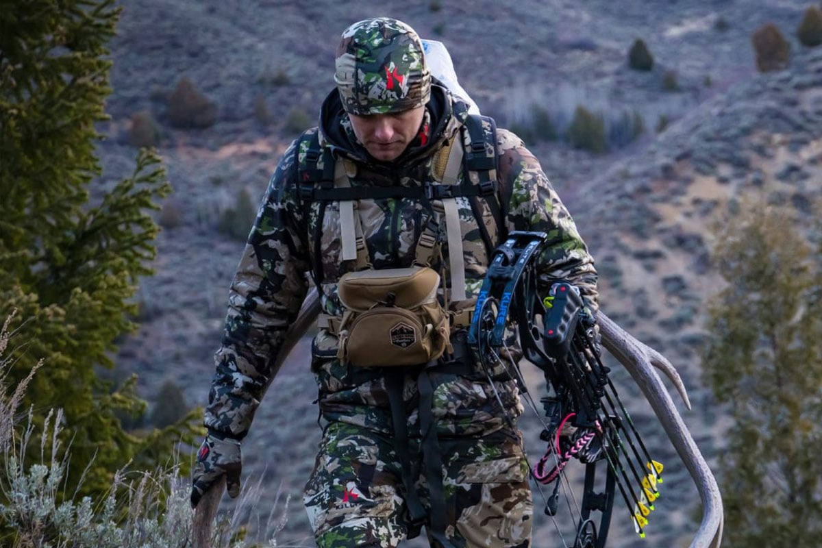 Man walking in mountain with crossbow