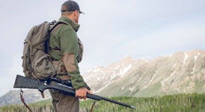 Man on mountain holding long range rifle