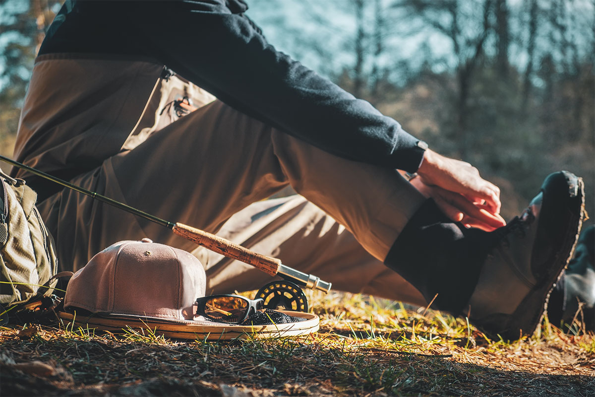 Man putting on wading boots to go fishing