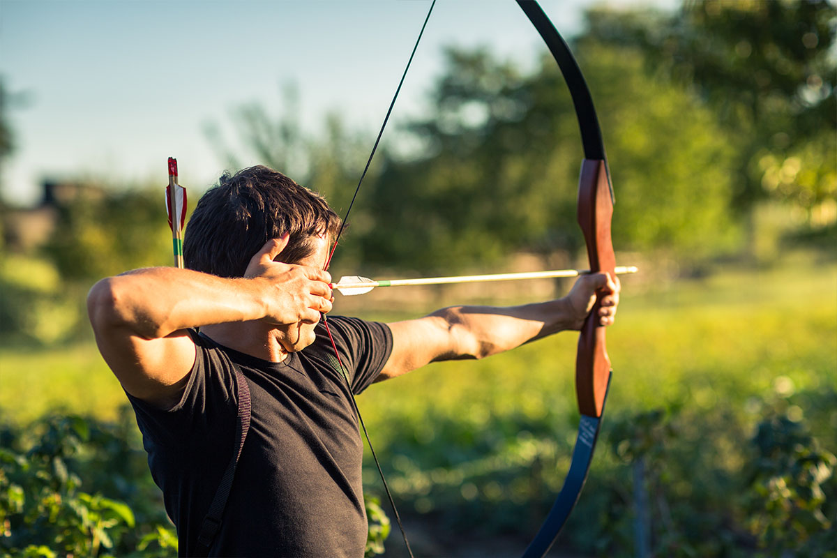 Man shooting longbow