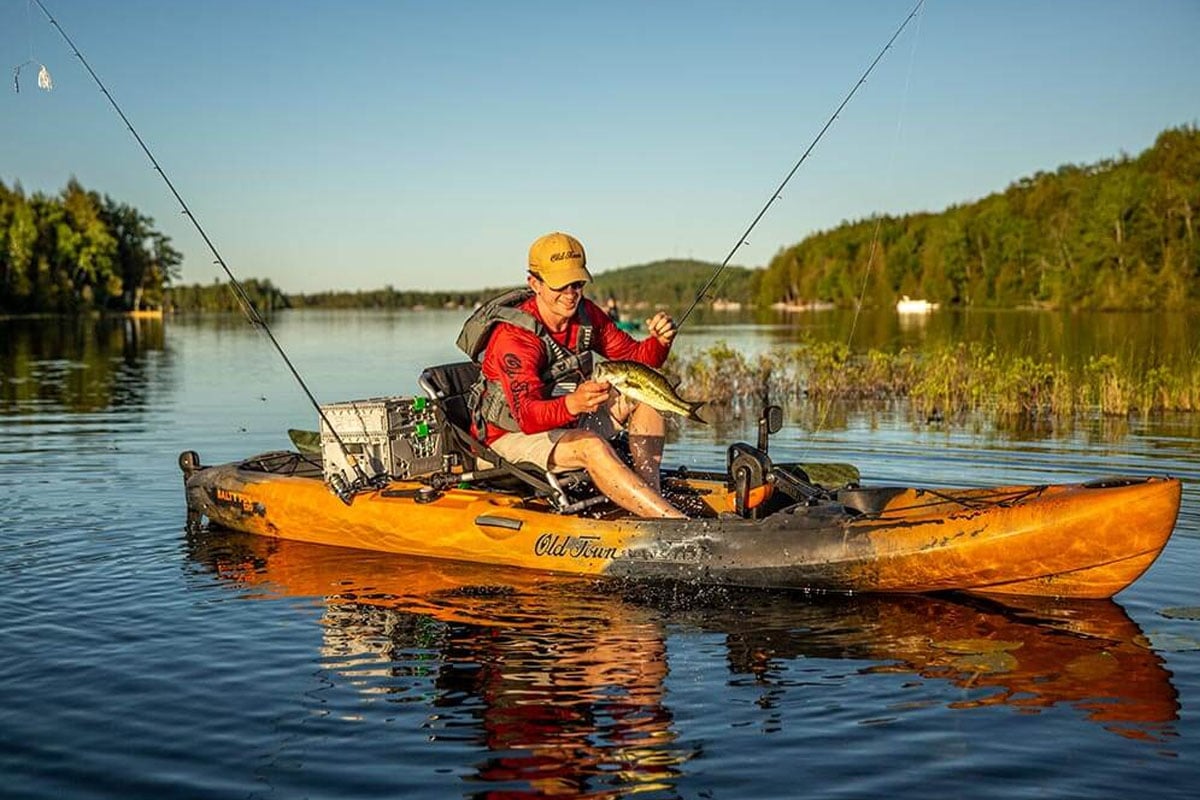 Guy fishing on a kayak on the lake