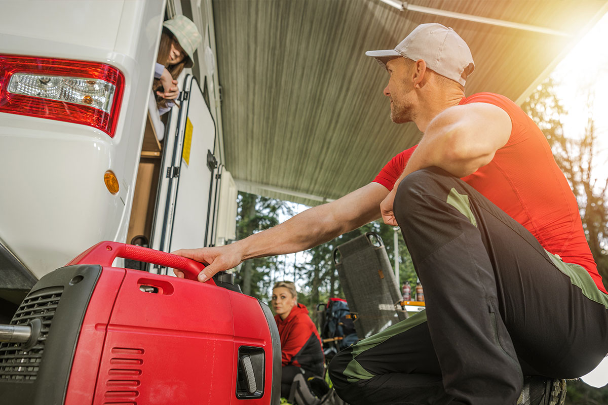  Man using a portable power generator while camping