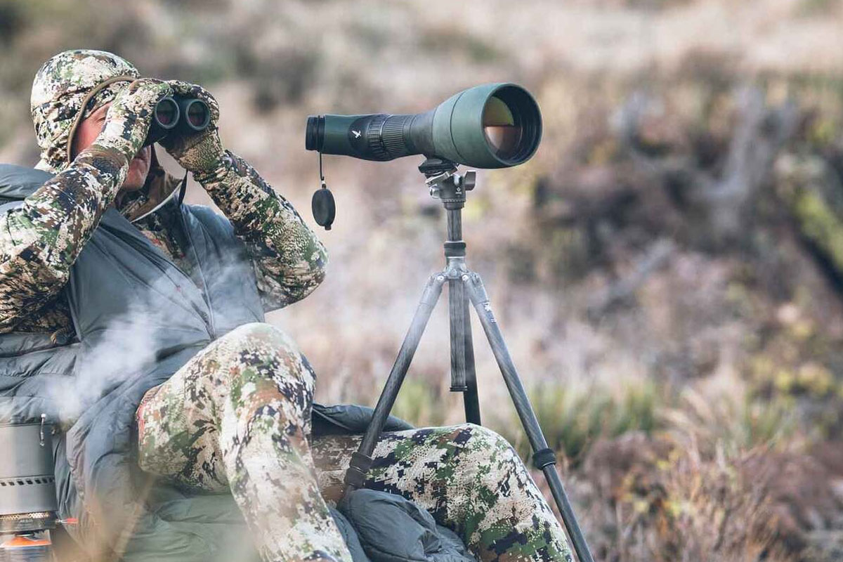 Man hunting using a spotting scope