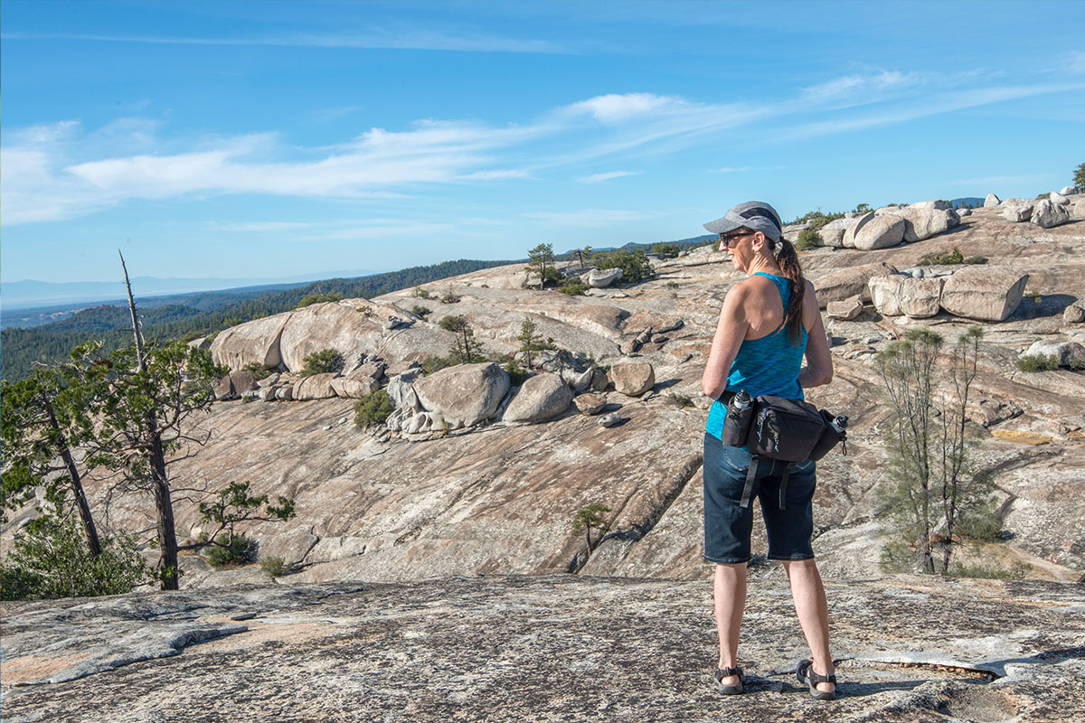 woman in mountains with waist pack hiking