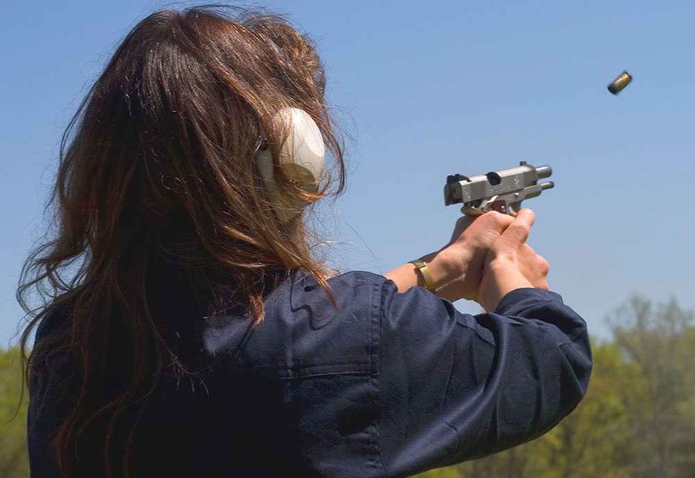 handgun recoiling in womans hand